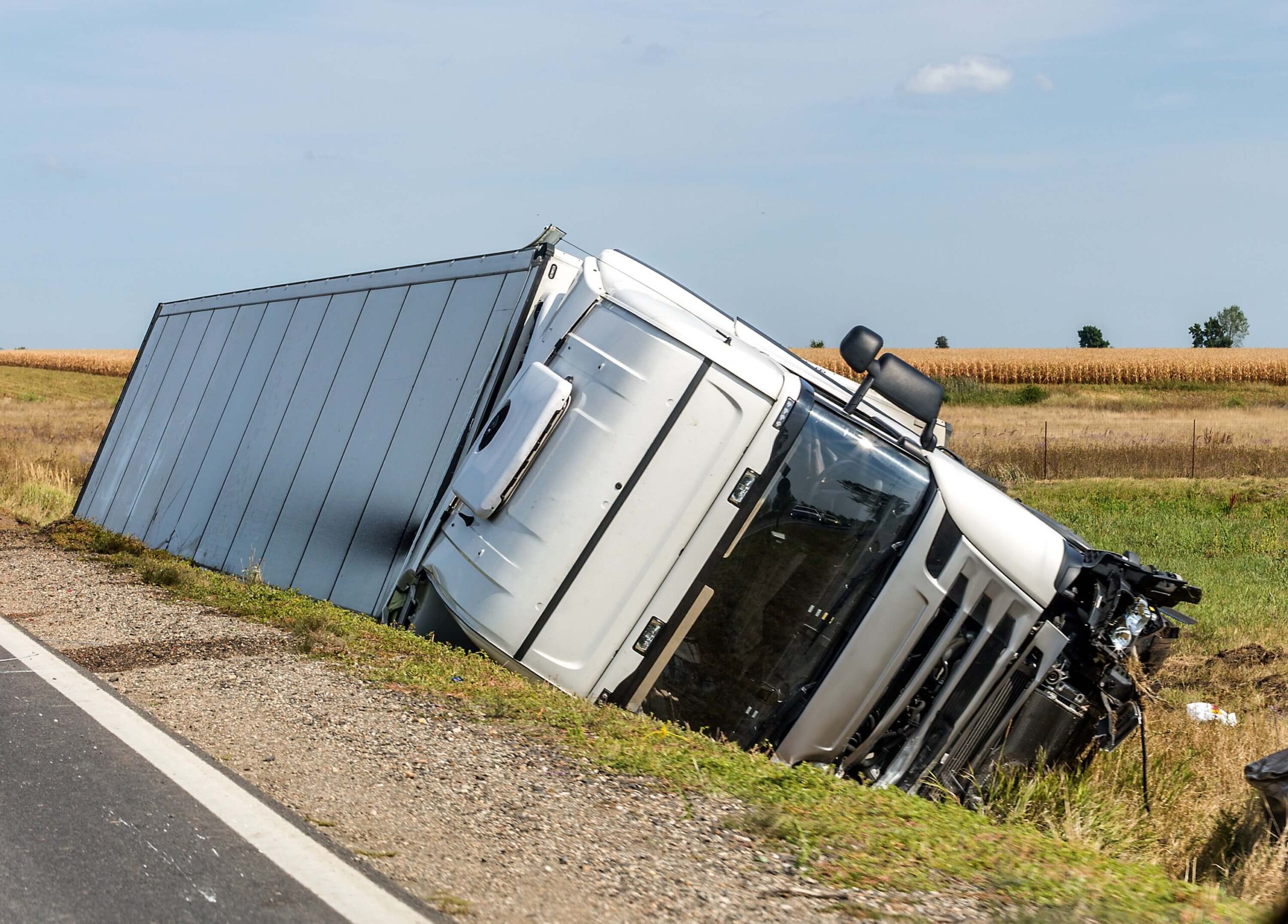 The large truck is located in a side ditch after the accident.